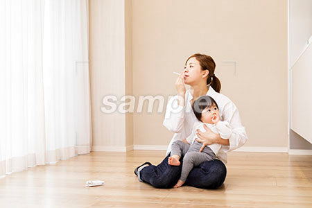 赤ちゃんをあやしながら煙草を吸う母親 a0030355PH