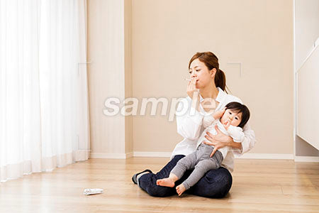 赤ちゃんを抱えてタバコを吸う母親 a0030357PH