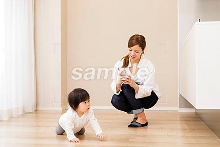 はいはいする赤ちゃんをスマホで撮影する母親 a0030358PH