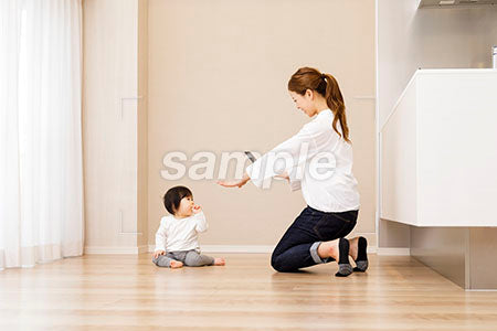 床に座る赤ちゃんをスマホで撮る母親 a0030360PH