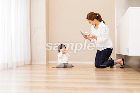 座る赤ちゃんを撮影するママ a0030369PH