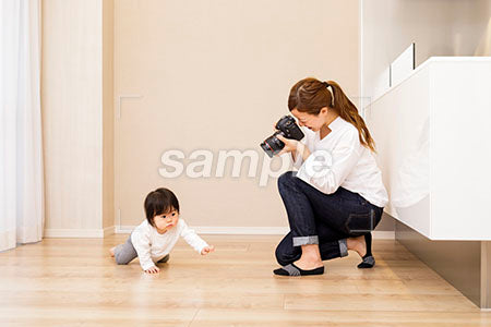 ハイハイして歩く赤ちゃんをカメラで撮るお母さん a0030376PH