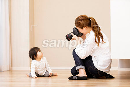 床に座る赤ちゃんをカメラで撮る母親 a0030378PH