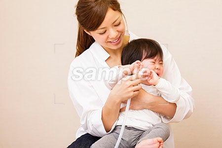 風邪をひいた赤ちゃんの鼻水吸引をするママ a0030398PH