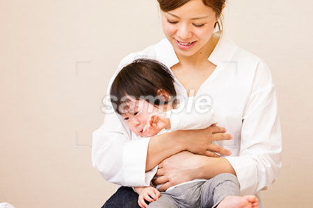 泣く赤ちゃんを抱く若いママ a0030401PH
