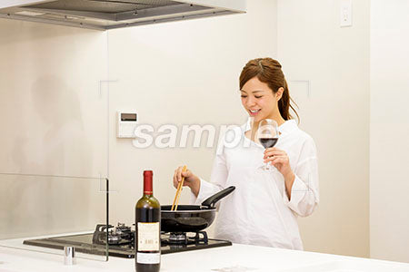 料理をしながらワインを飲む20代の女性 a0030413PH