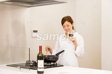 料理をしながらワインを飲む女性 a0030415PH