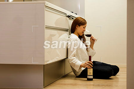 料理をしながら赤ワインを飲んでよっぱらう女の人 a0030424PH