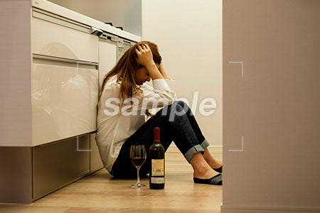 頭を抱える女性 キッチンの床に座って頭を抱える a0030427PH