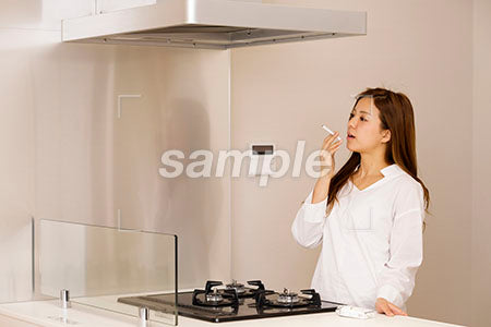 料理をしながら喫煙する若い女性 a0030431PH