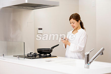 キッチンで携帯を見る女性 a0030433PH