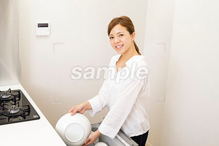 女性がキッチンで皿を収納する a0030441PH
