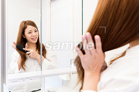 女性が鏡の前で髪をブラシする a0030445PH