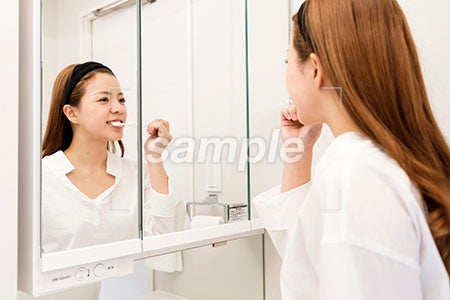 洗面台の鏡の前で歯を磨く a0030455PH
