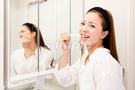 歯を磨きながら振り返って笑顔の奥さん a0030457PH