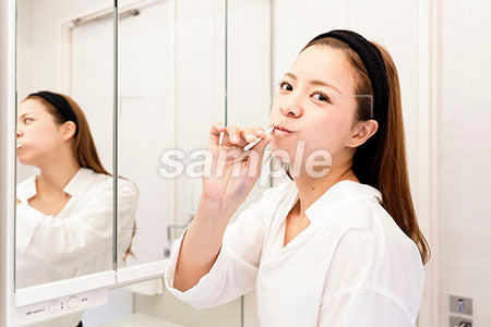 歯を磨く女性 歯を磨きながら振り返る a0030460PH