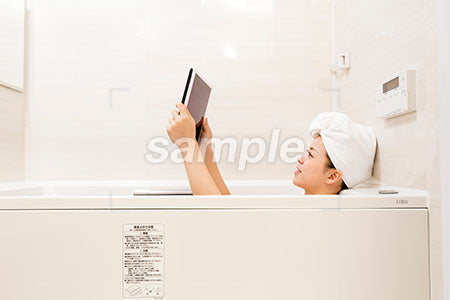 お風呂でタブレットで本を読む女性 a0030490PH