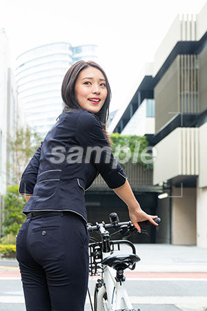 自転車を押しながら振り返って笑う女の人 a0040099PH