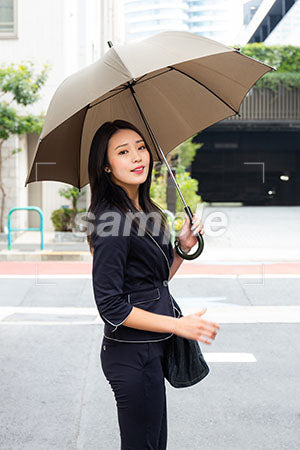 雨天で、傘をさして振り返って笑う a0040137PH