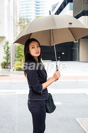 出勤中の傘をさして振り返えるOL a0040139PH