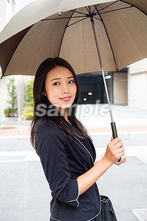 出勤中のOLが傘をさして左を見て微笑む a0040142PH