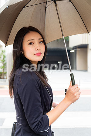 女性が傘をさして振り返って微笑む a0040144PH