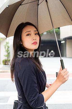 憂いのある顔で傘をさして振り返る女性 a0040145PH