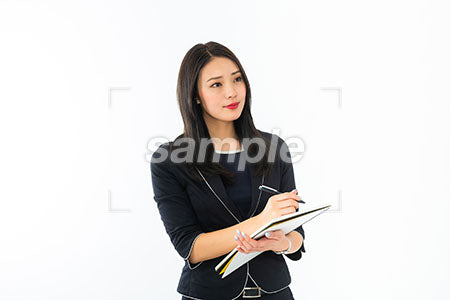 ペンを持って議事録を記載する女性 a0040227PH