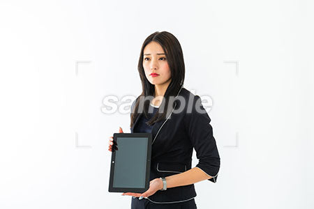 女性が悲しそうにがタブレットの画面を見せて左を見る a0040346PH