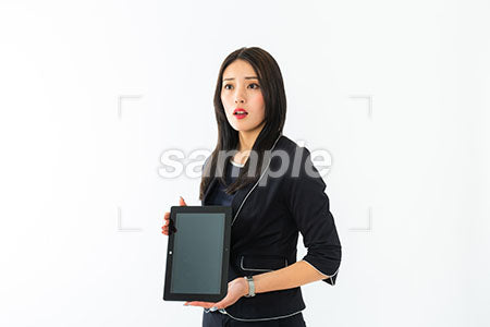 女性がタブレットの画面を見せて左上を見て驚く a0040350PH