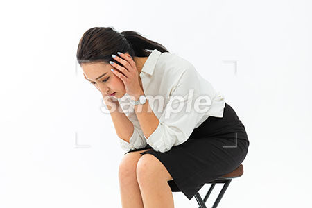 椅子に座って頭を抱え落ちこむ女性 a0040387PH