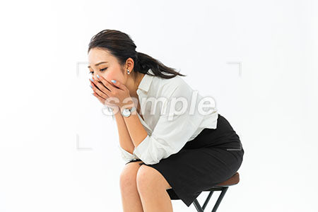 女性が椅子座って口を手で覆う、落ち込んでいる a0040389PH