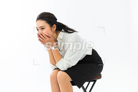 椅子に座って座って口を手で覆う女性 a0040390PH