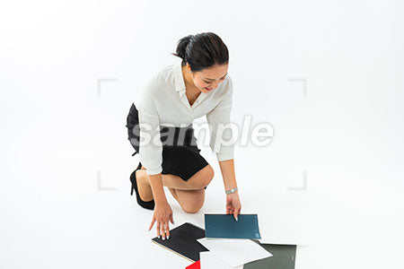女性が床に散乱した文房具を拾う a0040432PH
