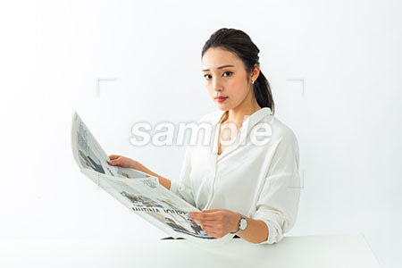 新聞を読みながら正面を見る女性OL a0040512PH
