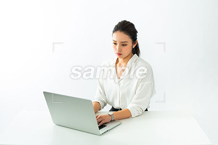 ふてくされながらパソコン仕事をする女性 a0040523PH