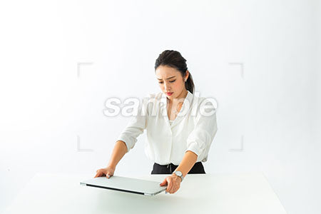 パソコンを机にたたきつける女性 a0040542PH