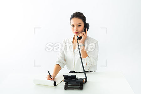 受付の女性が電話しながら電話しながらメモを取る a0040543PH
