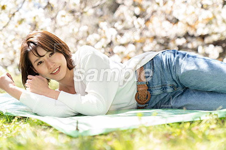 緑の草の上で寝る20代の女性 a0050156PH