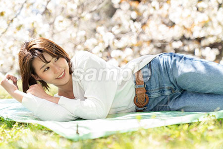 女性が公園で横にななって顔を上げるシーン a0050157PH