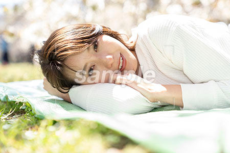 芝生の上で寝る女の人のアップシーン a0050164PH