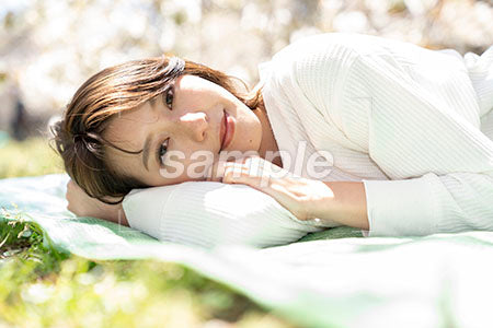 桜の公園で横になって寝ている美人女性 a0050165PH