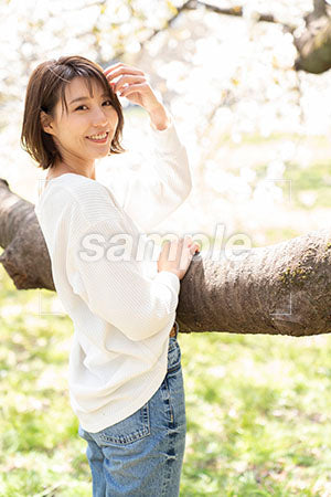 桜の枝の前に立って振りかえる美人 a0050226PH