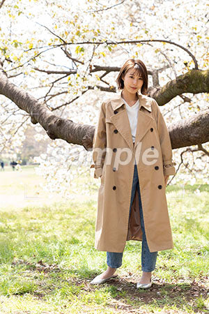 広場で枝の前に立って正面を見る女性 a0050241PH