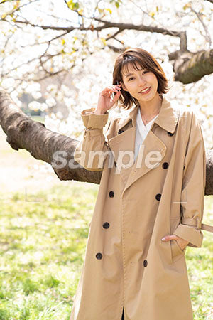 桜の下に立つ女性、正面で笑顔 a0050245PH