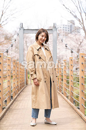 つり橋の上に立つ女の人が正面を見る a0050254PH