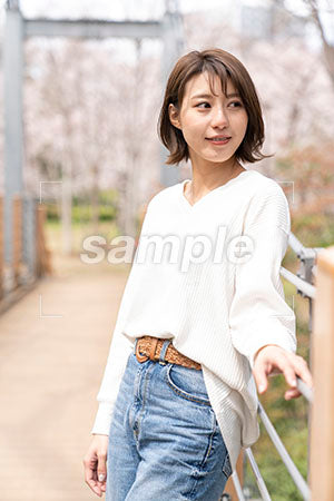 つり橋の上に立つ白い服を着た女性 右を見る a0050282PH