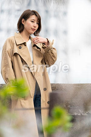 冬の季節にトレンチコートを着ている女性が横を向く a0050330PH