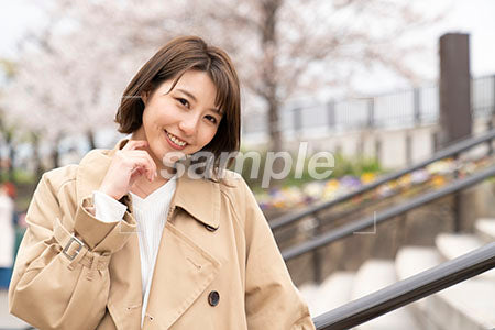 外の階段に立つ女性が笑顔で正面を見る a0050374PH