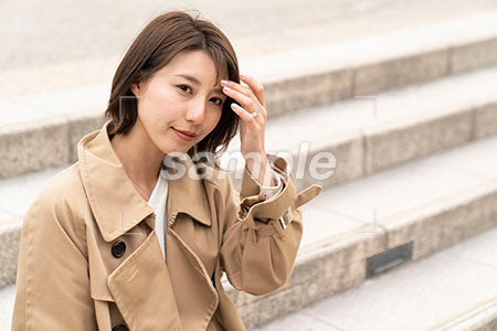 公園の階段に座って正面を見る女性 a0050427PH